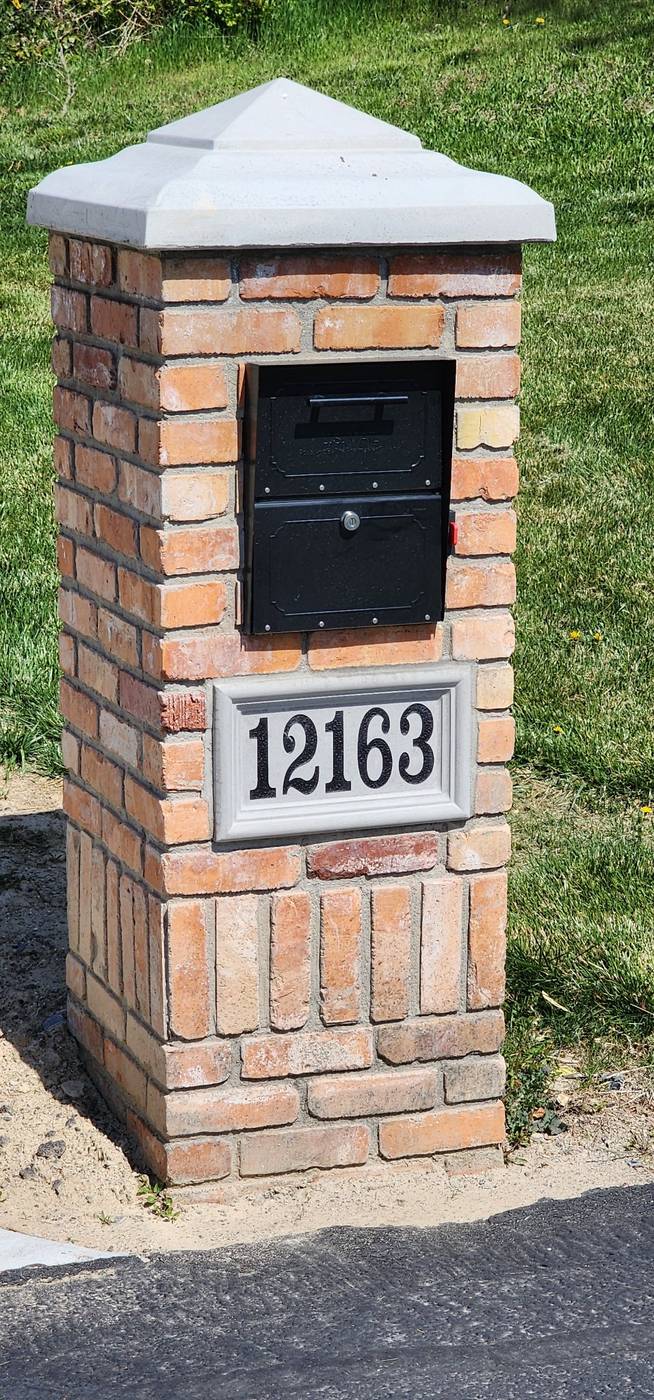 Brick mailbox pillar with stone cap