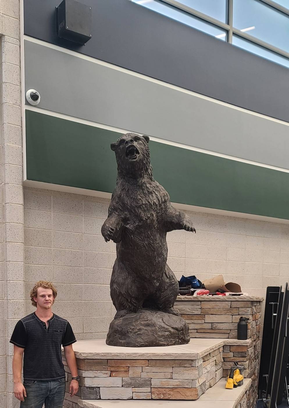 Stone pedestal and bear statue, school gym