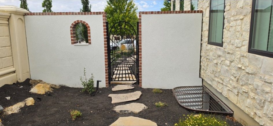 After: stucco finish with brick trim around the arched window