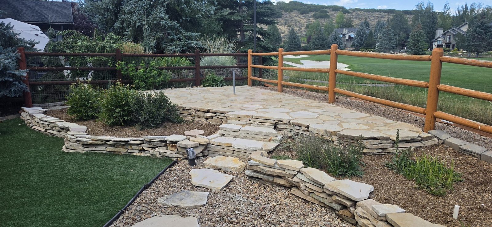 After: renewed flagstone patio with stacked-stone retaining walls